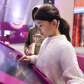 A child interacts with an interactive display at a science museum.