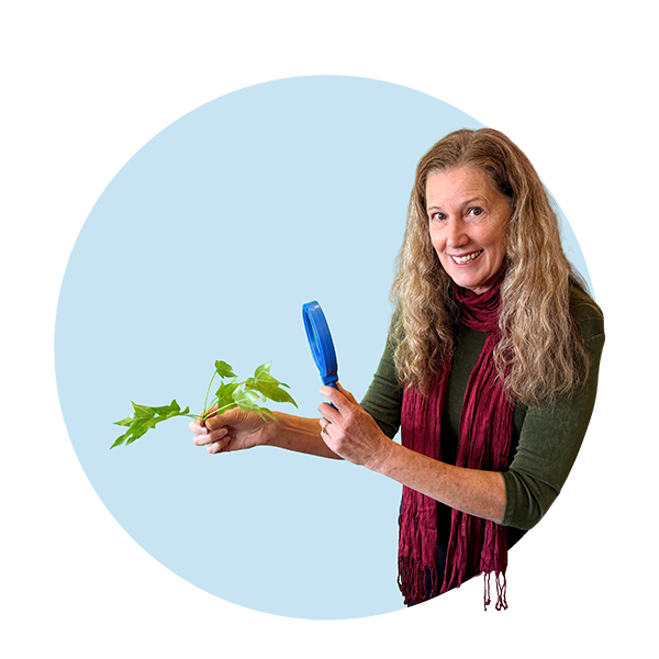 Community Science Hero Jenny Hartigan, holding a branch and magnifying glass